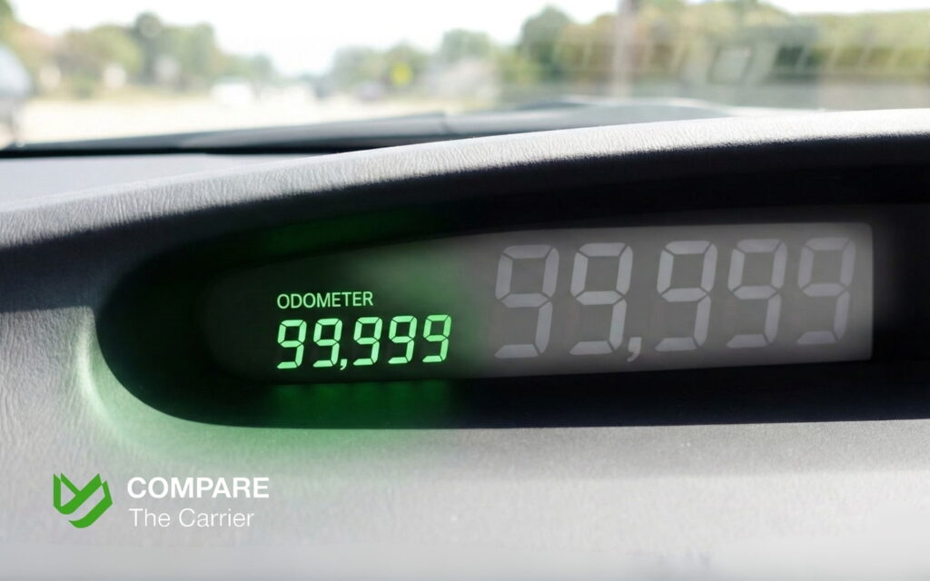 Digital car dashboard showing the odometer approaching 100,000 miles.