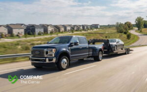 Hot shot truck hauling a car on a wedge trailer down a residential street, illustrating fast and door-to-door vehicle transport.