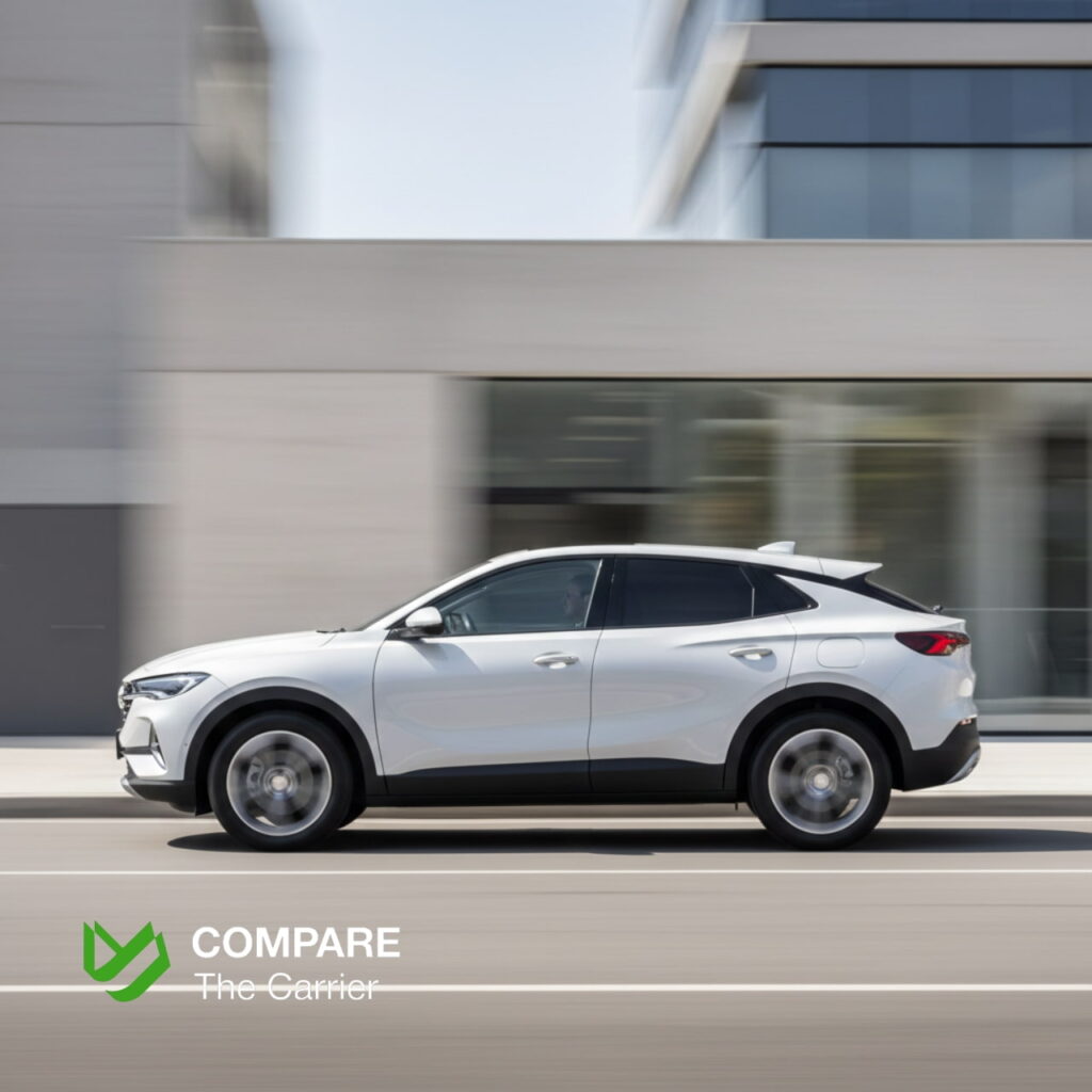 Side profile of a 2026 Buick Envista driving through a modern neighborhood, showcasing its sleek coupe-like silhouette.