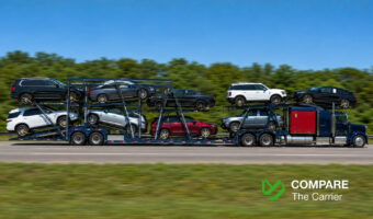 Open car hauler truck transporting American vehicles on a highway in a tandem configuration.